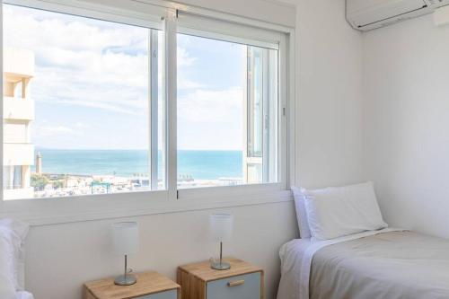 Schlafzimmer mit einem Bett und einem Fenster mit Meerblick in der Unterkunft SEAVIEW Estepona Marine Port with POOLS in Estepona