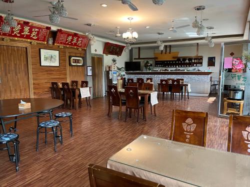a restaurant with tables and chairs and a bar at Ye Jiang Hua Homestay in Meishan