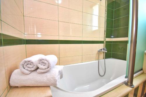 a bathroom with two towels sitting on a bath tub at The Stone Villas in Áno Korakiána