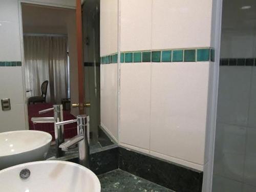 a bathroom with two sinks and a shower at Hotel Montecarlo Santiago in Santiago