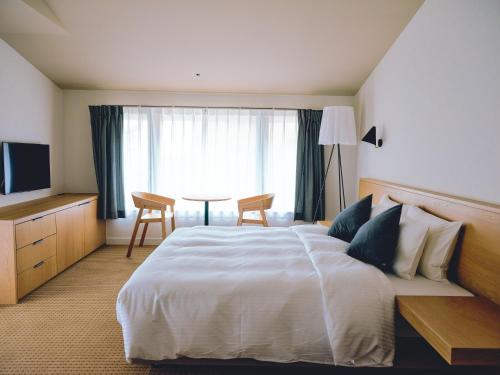 a hotel room with a large bed and a table at BIRD HOTEL in Kamakura