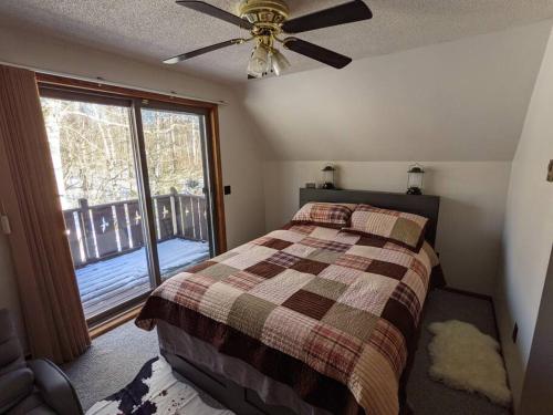 a bedroom with a bed and a ceiling fan at Wildlife Chalet - Sauna Lakeview Firepit Wifi in Tofte