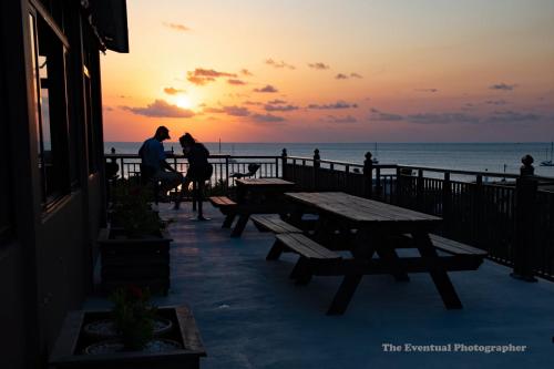 two people standing on a pier looking at the ocean at Coral View Hotel & Resort in Caye Caulker