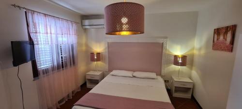 テッラジーニにあるVoilà Rooms Guest Houseの小さなベッドルーム(ベッド1台、ナイトスタンド2台付)