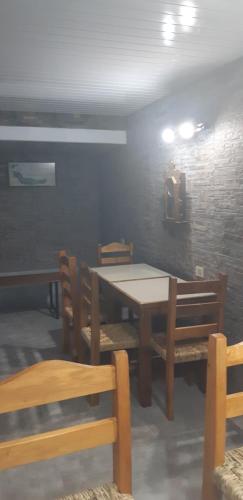 a dining room with a table and wooden chairs at Mykonos Carmelo in Carmelo