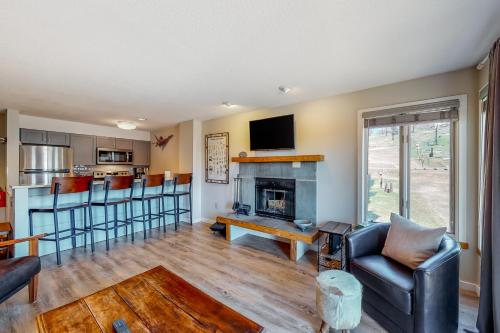a living room with a couch and a fireplace at Okemo Mountain Lodge B203 in Ludlow