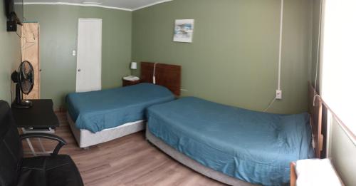2 Betten in einem kleinen Zimmer mit blauer Bettwäsche in der Unterkunft Alojamientos JV HABITACIONES in Nogales