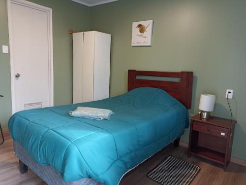 ein Schlafzimmer mit einem blauen Bett und einem Nachttisch in der Unterkunft Alojamientos JV HABITACIONES in Nogales