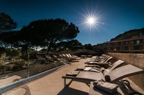 a row of chaise lounges sitting on a patio at Roccamare Resort - Ville e Appartamenti in Castiglione della Pescaia