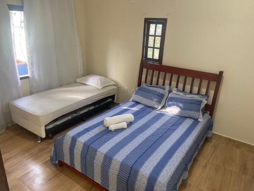 um quarto com 2 camas com lençóis azuis e brancos em Hostel Blue House Búzios em Búzios