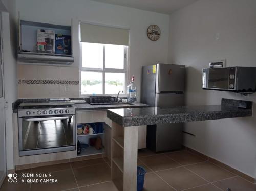a kitchen with a stove and a refrigerator at Condominio con la mejor vista in Cancún