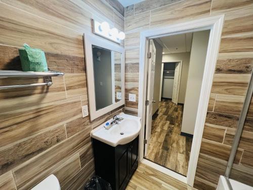 La salle de bains est pourvue d'un lavabo et d'un miroir. dans l'établissement Haiban Inn Jersey City, à Jersey City