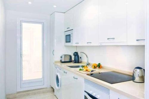 マルベーリャにあるBEST LOCATION apartment in MARBELLA. BEACHFRONT!!の白いキッチン(シンク、食器洗い機付)