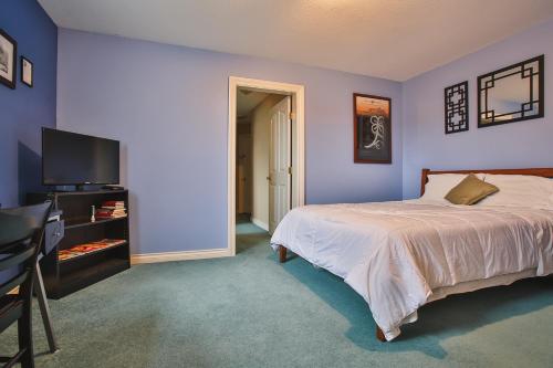 1 dormitorio con 1 cama y TV de pantalla plana en Eagle Close Executive B&B, en Prince Rupert