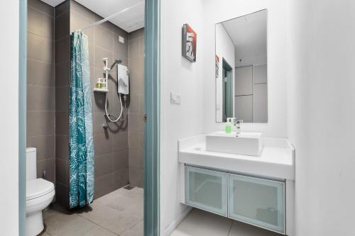 a bathroom with a sink and a toilet and a mirror at Summer Suites KLCC Apartments by soulasia in Kuala Lumpur