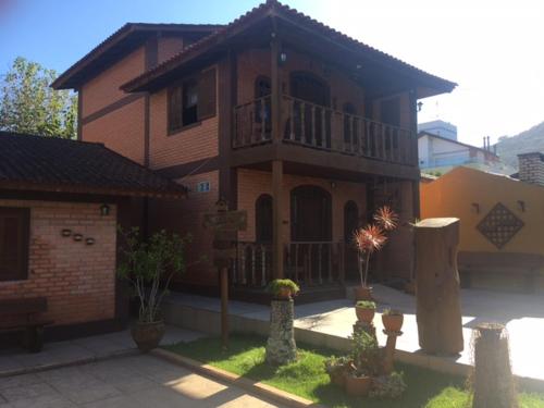 a large brick house with a porch and a balcony at Toca do Moa in Florianópolis