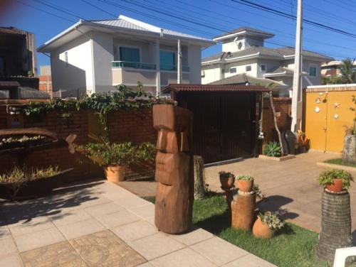 uma estátua de madeira num quintal em frente a uma casa em Toca do Moa em Florianópolis