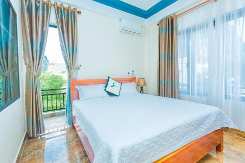 a bedroom with a bed and a large window at Phong Nha Green Homestay in Phong Nha