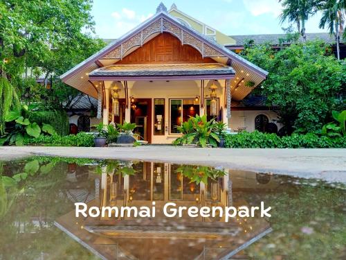 a house with a reflection in a pool of water at Rommai Greenpark in Lampang