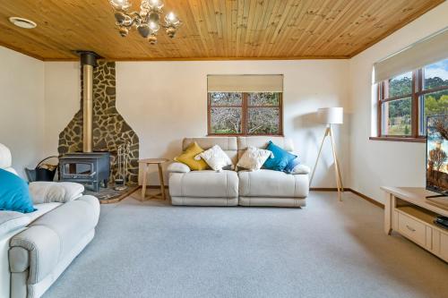 a living room filled with furniture and a large window at Blackwood Park Cottages Mole Creek in Mole Creek