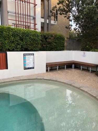 a swimming pool with a bench and a table and a bench at Large Family Sized Unit with Watersports, Maroochy River, Lagoon, and Beach Access in Twin Waters