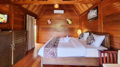 a bedroom with a bed in a wooden room at Cersen Resort Lombok in Kuta Lombok