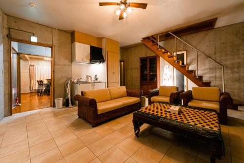 a living room with two couches and a table at Pine House in Ginoza in Ginoza