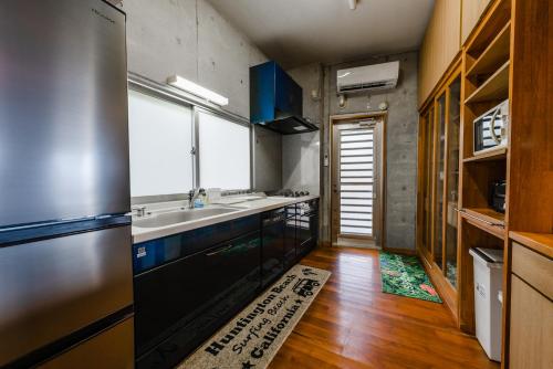a kitchen with a sink and a refrigerator at Pine House in Ginoza in Ginoza