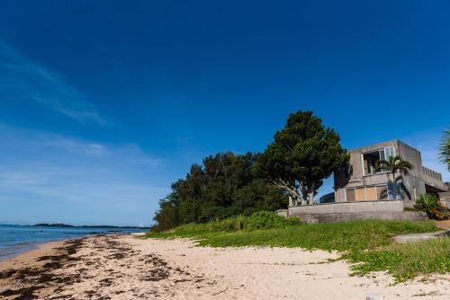 a house on the beach next to the water at Pine House in Ginoza in Ginoza