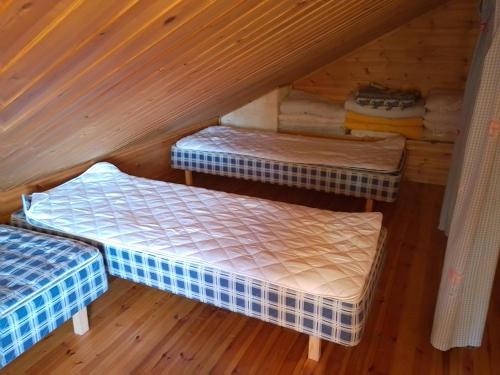 una habitación con 3 camas en una cabaña en Kuvalusdream Chalet, en Lintusalo