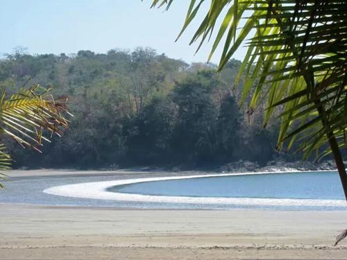 una playa con una piscina de agua y árboles en Pacific Bay Resort, en Boca Chica