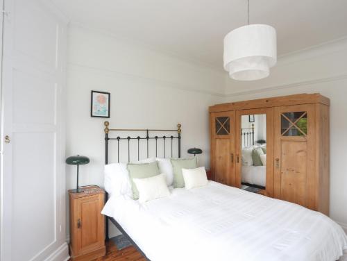 a bedroom with a large white bed and a wooden cabinet at Summerfield in Conwy