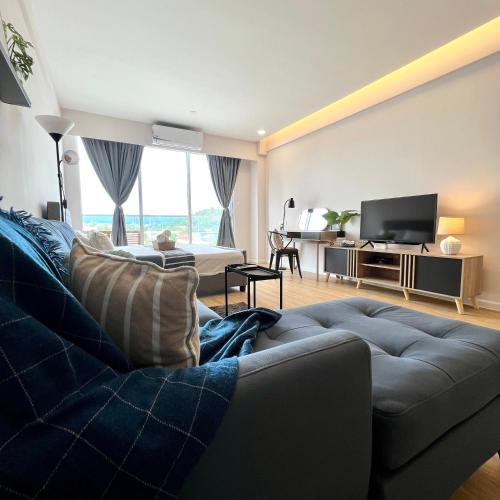 a living room with a couch and a television at AruSuites Tanjung Aru Kota Kinabalu By LAXZONE in Kota Kinabalu