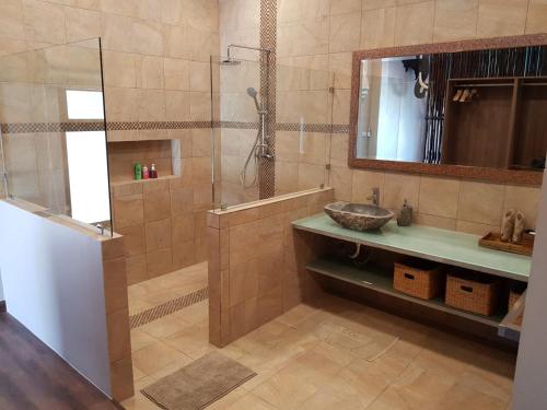 a bathroom with a shower and a sink and a mirror at Exotic Boutique Hotel in Khao Lak