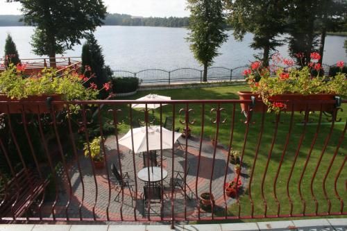a wrought iron fence with a table and flowers at Eva in Mrągowo
