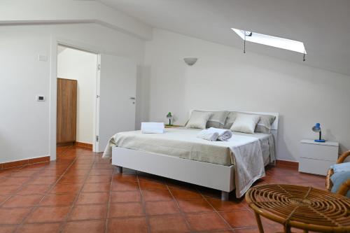 Un dormitorio blanco con una cama y una mesa. en Casetta Primo Sole Apartments, en Policoro