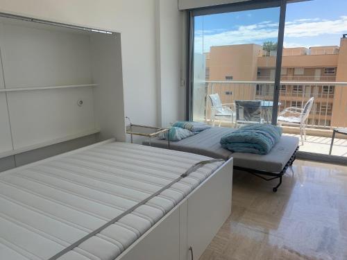 1 Schlafzimmer mit 2 Betten und einem großen Fenster in der Unterkunft F1 Exclusive Monaco Studio with Private Parking in Monte Carlo