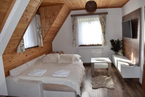 a bedroom with a white bed in a attic at FLORA HOUSE in Rastovača