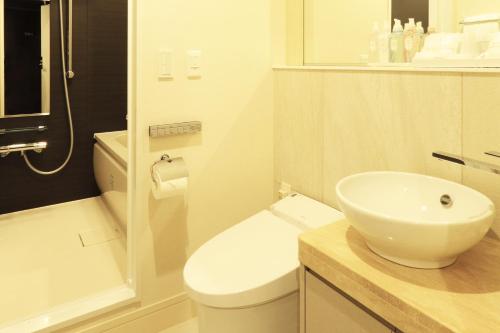 a bathroom with a white toilet and a sink at Centurion Hotel Grand Akasakamitsuke Station in Tokyo