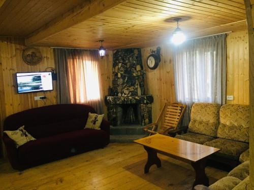 sala de estar con sofá y mesa en Mate Private Rooms, en Ushguli