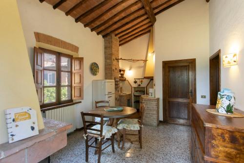 a kitchen with a table and chairs in a room at Agriturismo Poggio Salvi in Sovicille