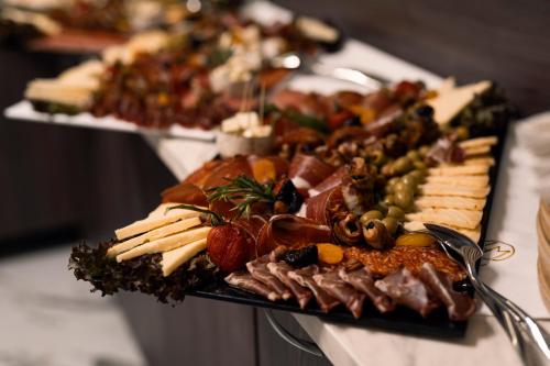 a tray of cheese and other appetizers on a table at Hotel Millennium by Aycon in Budva