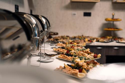 a buffet line with many plates of food on a counter at Hotel Millennium by Aycon in Budva