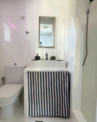 a bathroom with a sink and a toilet and a mirror at Serifos White in Serifos Chora