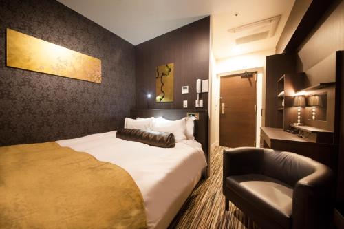 a hotel room with a bed and a chair at Centurion Hotel Grand Akasakamitsuke Station in Tokyo