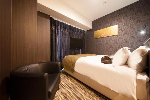 a hotel room with a bed and a chair at Centurion Hotel Grand Akasakamitsuke Station in Tokyo