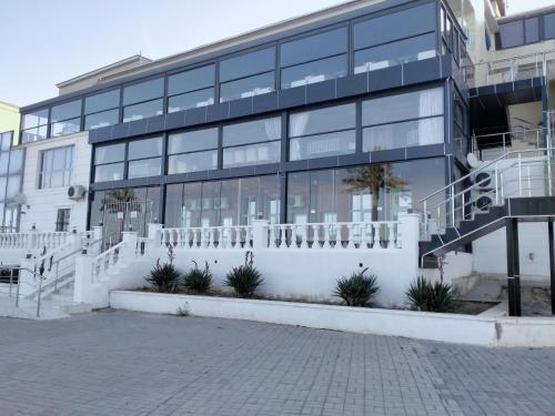 a large building with a white fence in front of it at Seaside apartment in Aktau