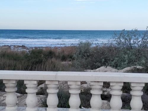 a white bench overlooking the ocean on a beach at Seaside apartment in Aktau