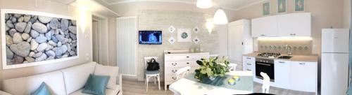 een keuken met witte kasten en een tafel in een kamer bij Caorle Villaggio & piscina in Caorle
