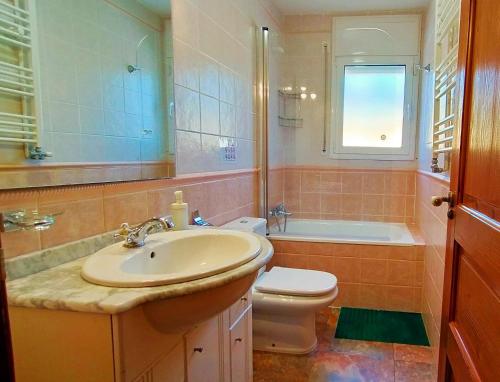 La salle de bains est pourvue d'un lavabo, de toilettes et d'une fenêtre. dans l'établissement VILLA DU LAC spéciale pour famille avec enfant, à Ríudecañas